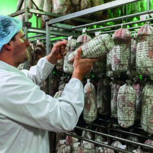 Personale specializzato al lavoro nella produzione: fase di mondatura e rifilatura manuale delle carni – Felino Parma